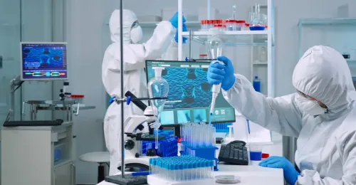 Trabajadores en el laboratorio con trajes de protección.